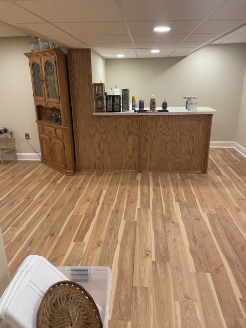 Finished basement rec room with custom bar and LVP hardwood flooring
