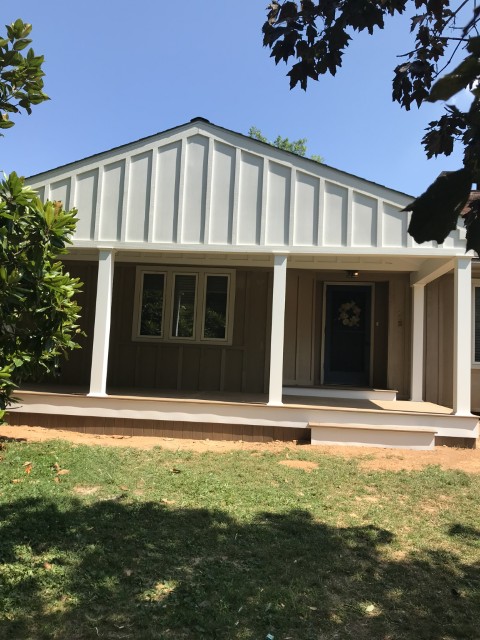 Completed room addition with board-and-batten siding and open covered front porch