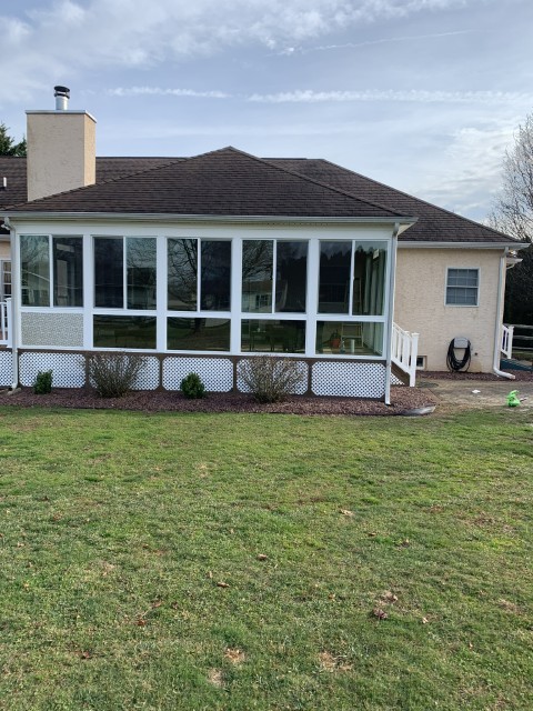 Screened porch addition with attached deck and white vinyl railing